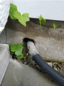 Unsealed utility pipe feeding into a gap in a cement wall 